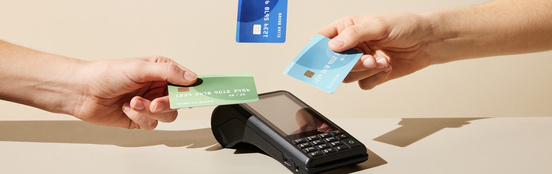 Drei Kreditkarten werden kontaktlos über ein EC-Terminal gehalten – NFC-Kartenzahlung am mobilen EC-Kartenlesegerät.